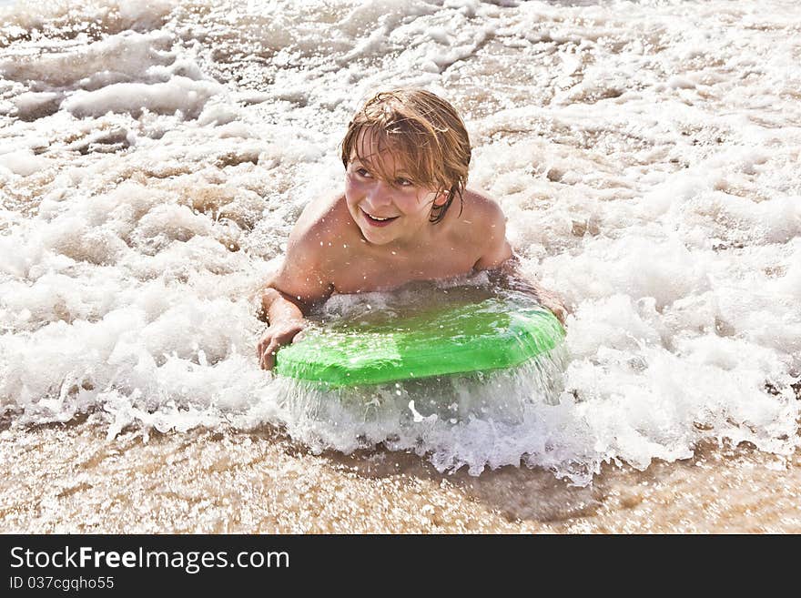 Boy has fun with the surfboard at the beach