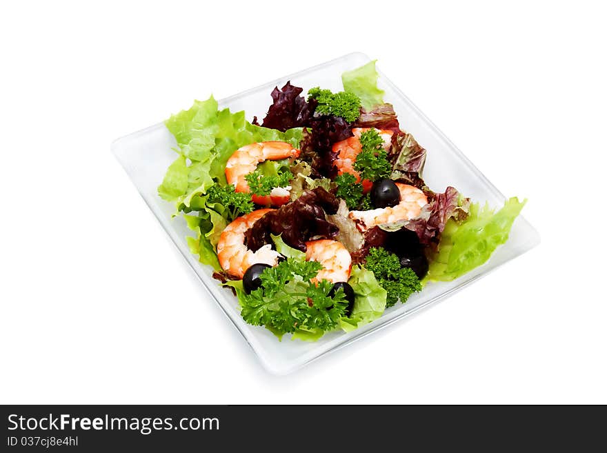 Salad with shrimp, black olives and herbs on a square platter