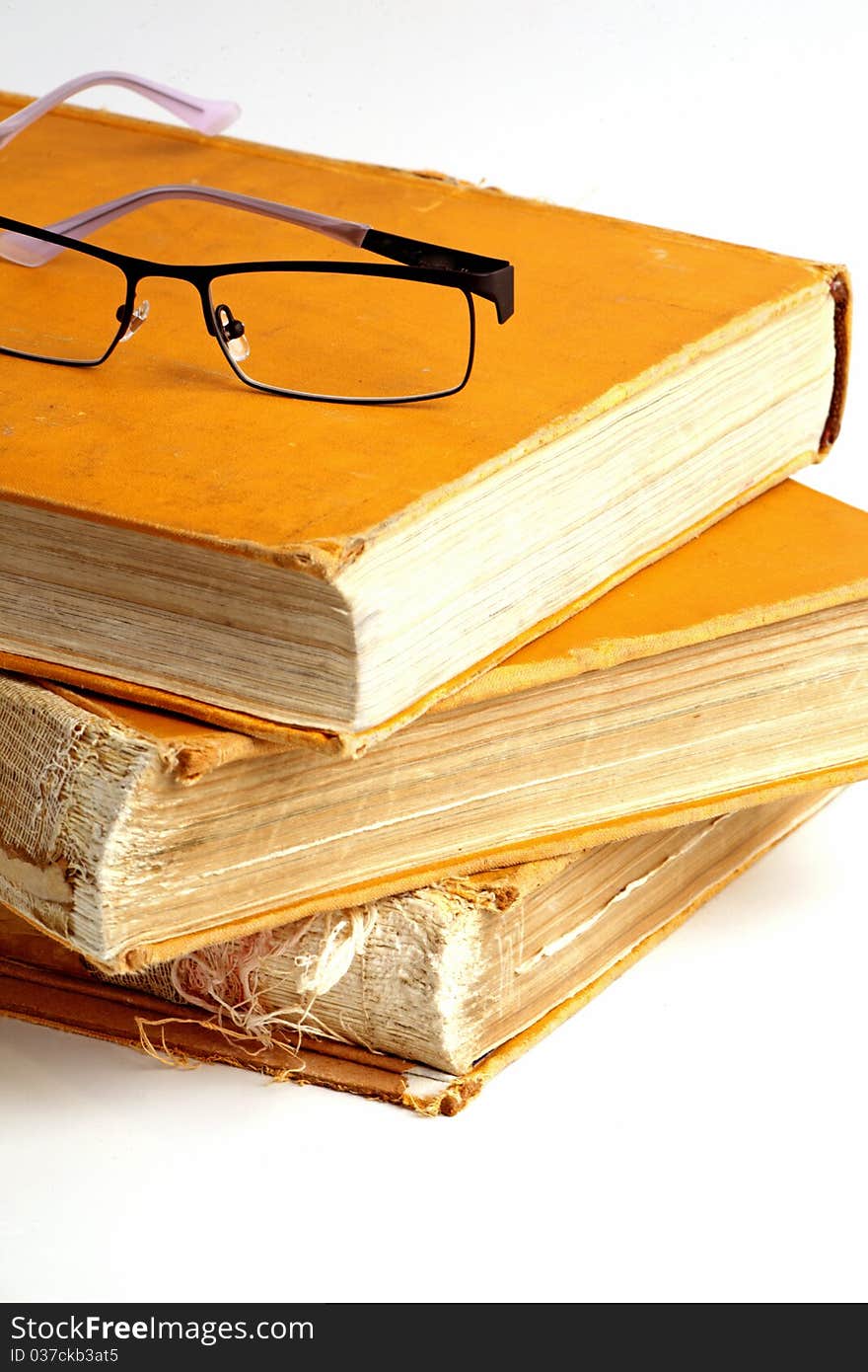 A very old encyclopedia and glasses