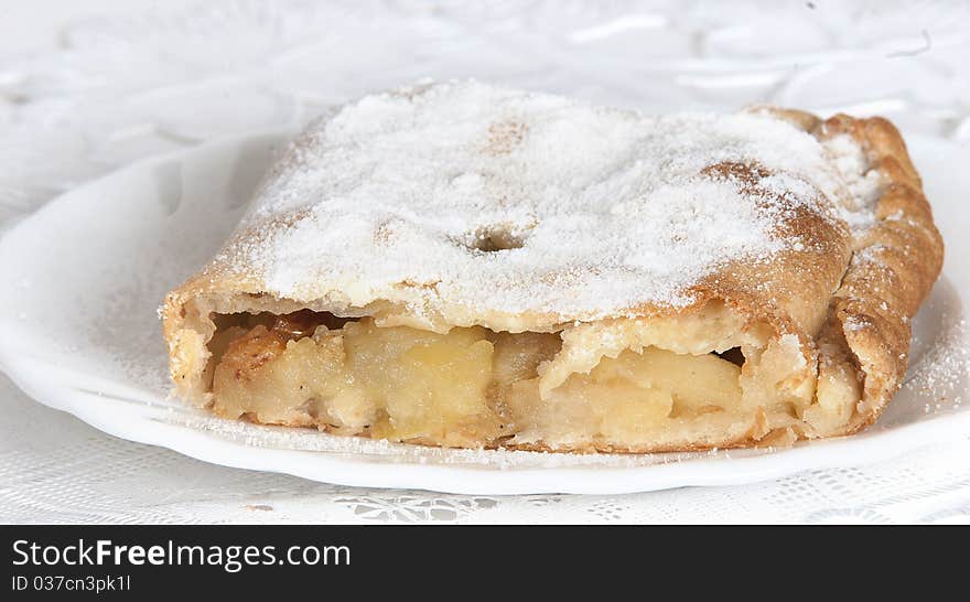 Piece apple strudel on a white plate on a light background. Piece apple strudel on a white plate on a light background