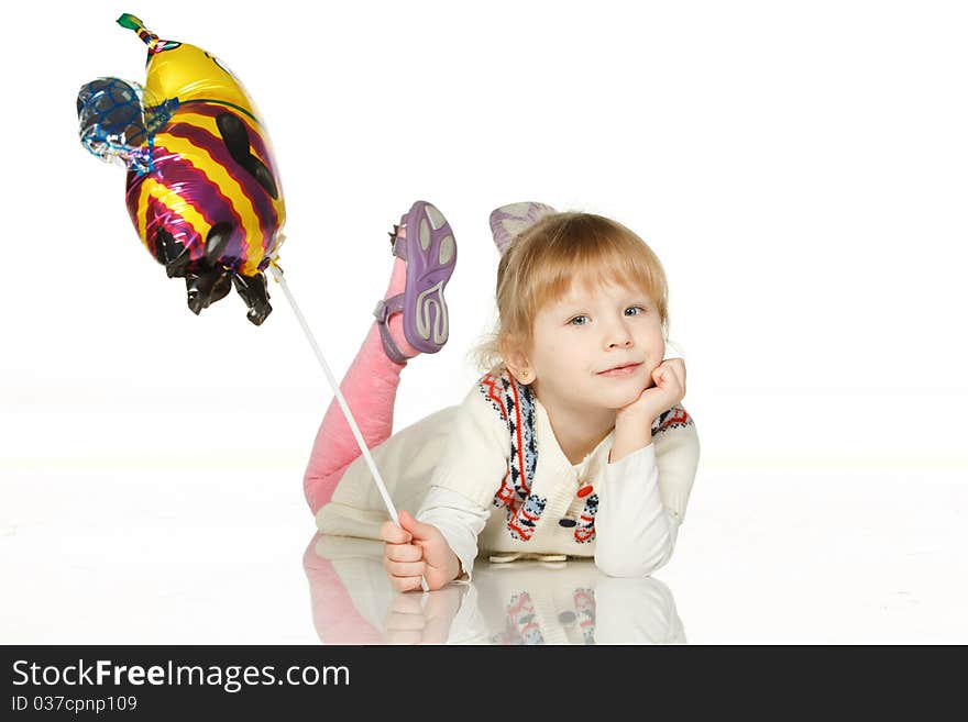 Kid lying on the floor with balloon bee