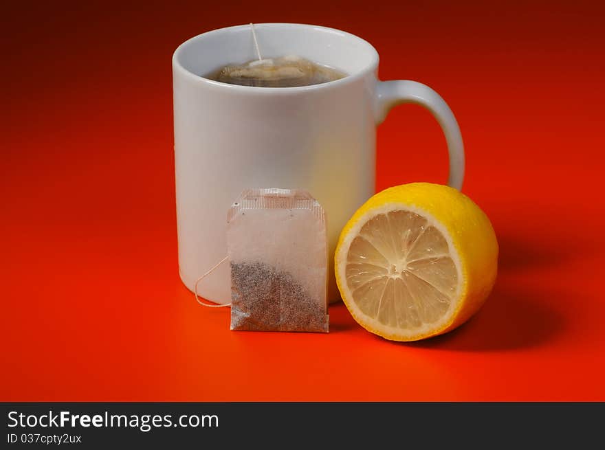 Cup of tea with lemon on a red background. Cup of tea with lemon on a red background