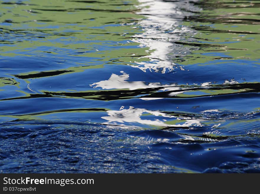 Blue and Green looking Water of a river, seen by using reflexions of a colored Facade of a Factory. Blue and Green looking Water of a river, seen by using reflexions of a colored Facade of a Factory