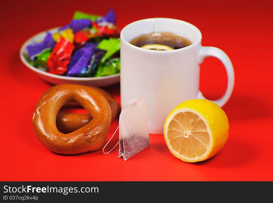 Cup of tea with lemon on a red background. Cup of tea with lemon on a red background