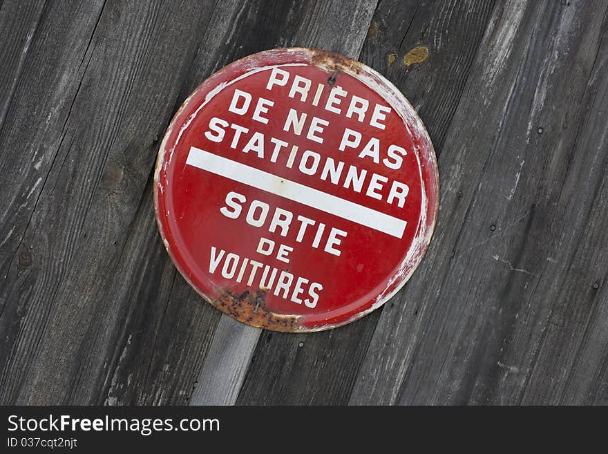 Old rusty forbidden parking sign isolated on wooden plank