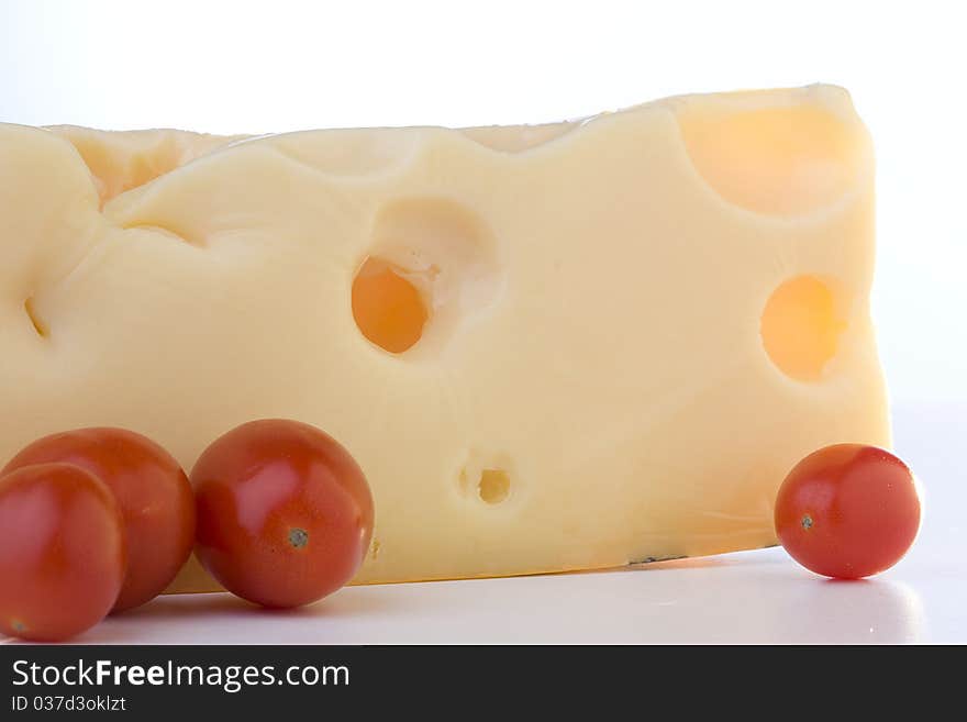 Swiss cheese slice with tomato on a white background. Swiss cheese slice with tomato on a white background.