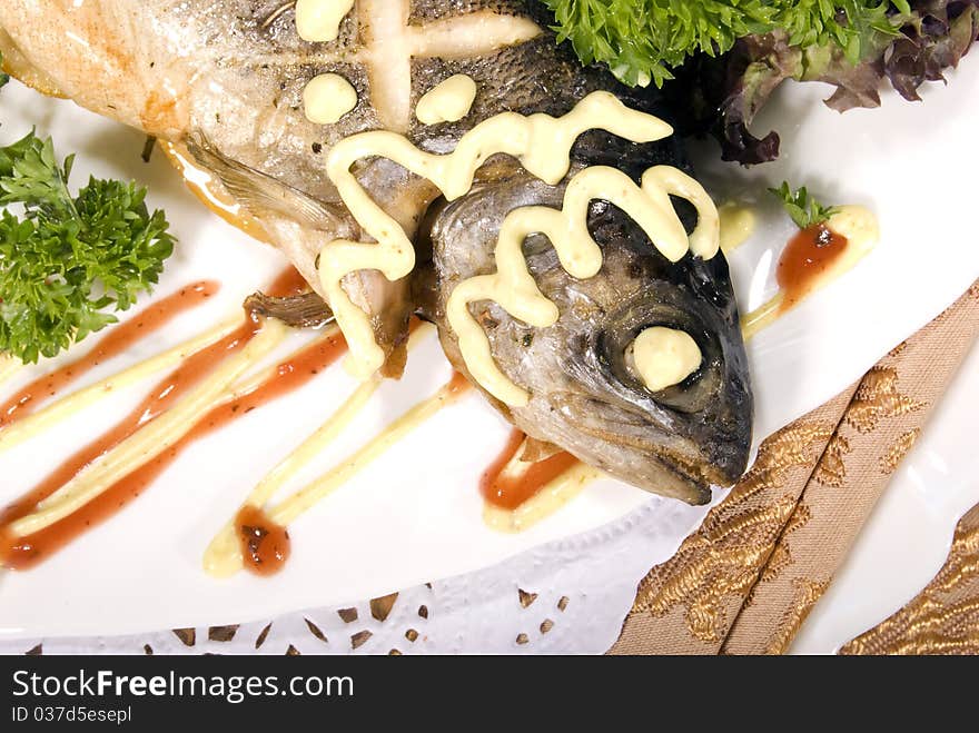 Stuffed baked fish served with lemon and salad