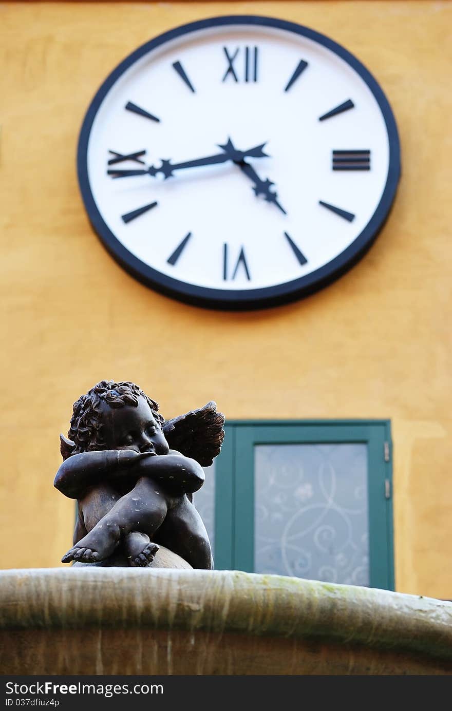 Statue of little cupid sitting under the clock. Statue of little cupid sitting under the clock