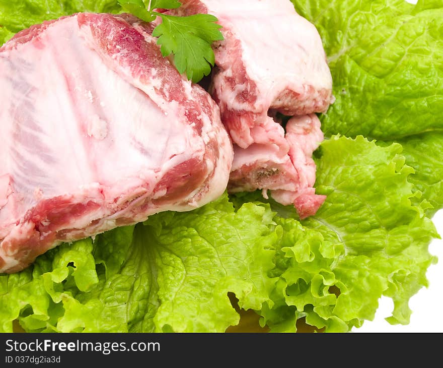 Several damp pigs of the bones with meat are found on sheet of the green salad. Several damp pigs of the bones with meat are found on sheet of the green salad