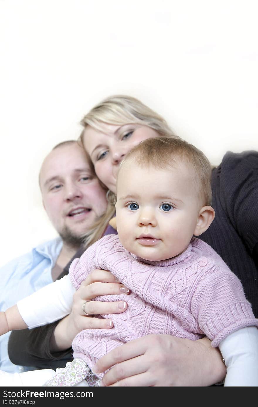 Baby with parents in background. Baby with parents in background