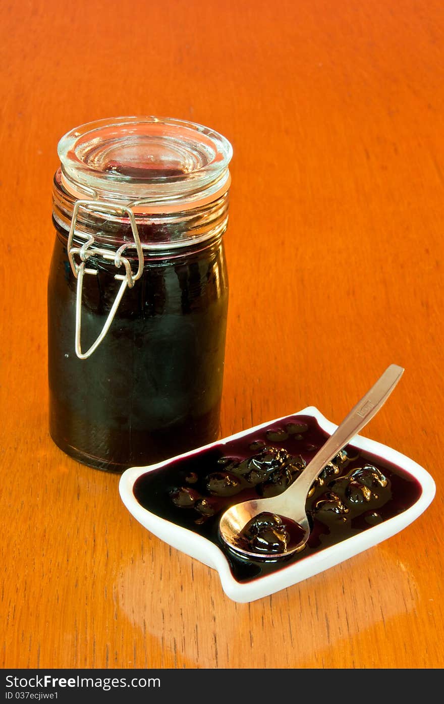 Jar and bowl of blackberry jelly with spoon