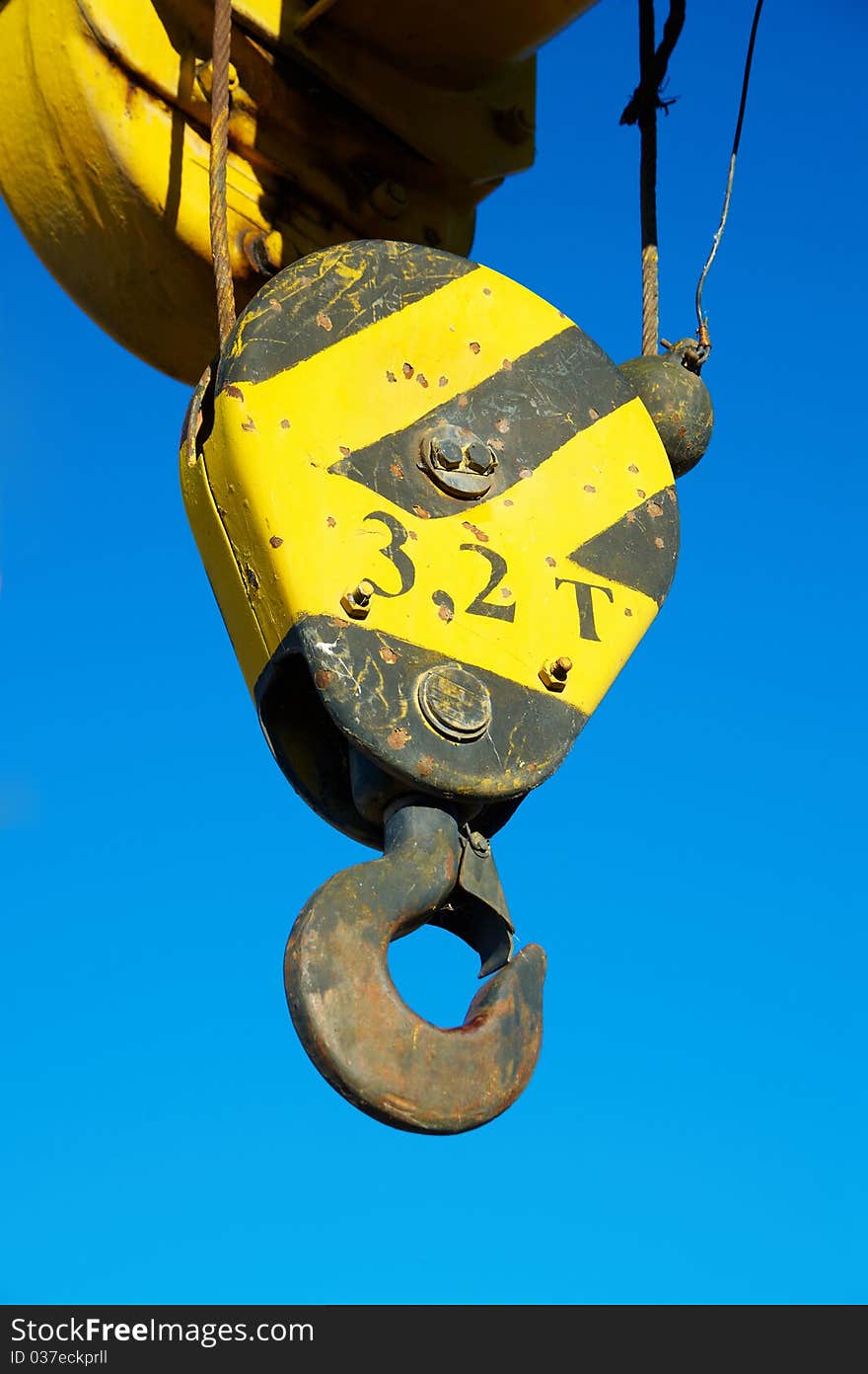 Hook of the elevating crane against the blue sky. Hook of the elevating crane against the blue sky