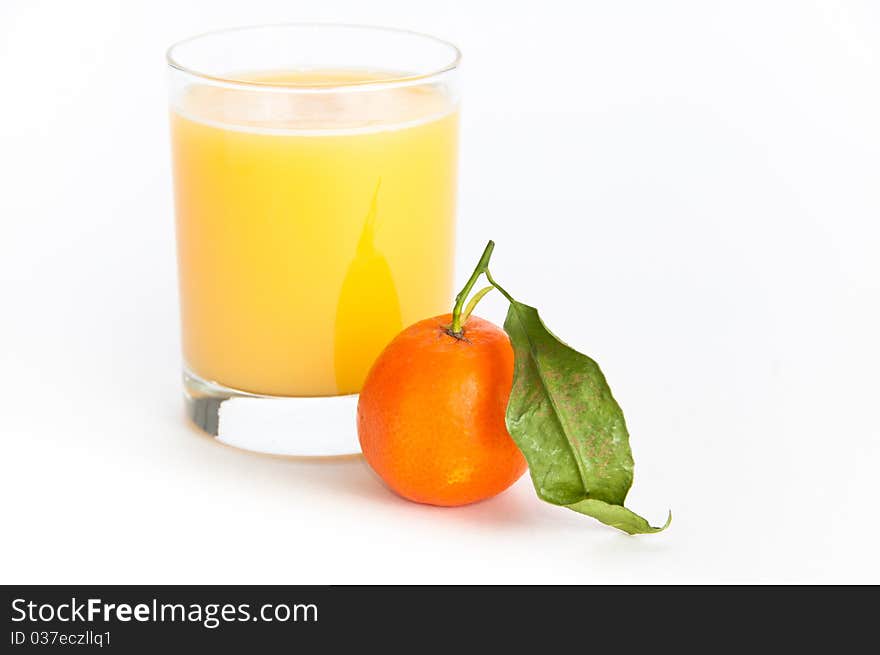 Glass of freshly squeezed orange juice and a single orange fruit with a leaf on isolating background. Glass of freshly squeezed orange juice and a single orange fruit with a leaf on isolating background