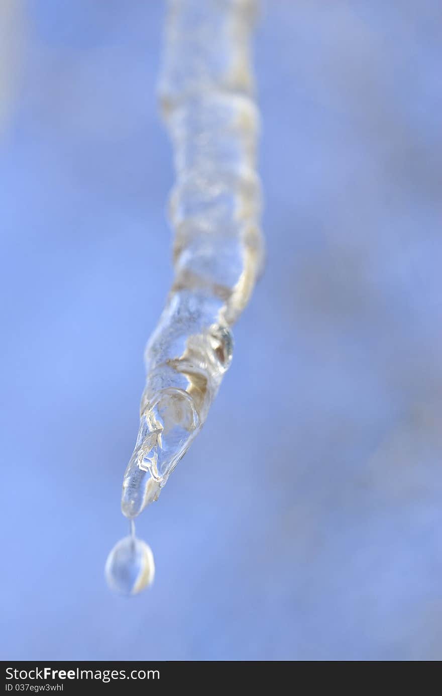 One icicle melting against the blue sky. One icicle melting against the blue sky.