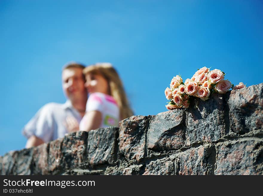 Bouquet of white and pink roses and lovers couple on background blue sky