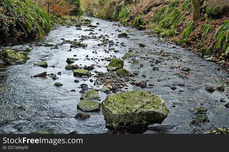 Babbling brook with large rock in the water flow