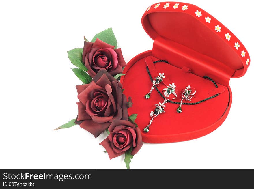 Platinum jewelry set in open red box and roses. Platinum jewelry set in open red box and roses