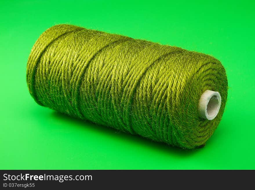 Bobbin of green thread on green background