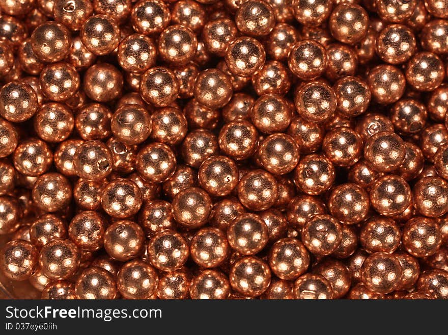 Closeup of a pile of shiny copper BB's.