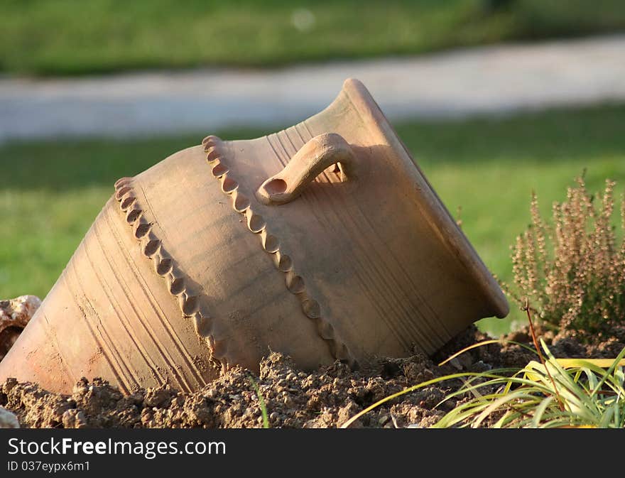 Ancient amphora on green grass in daylight