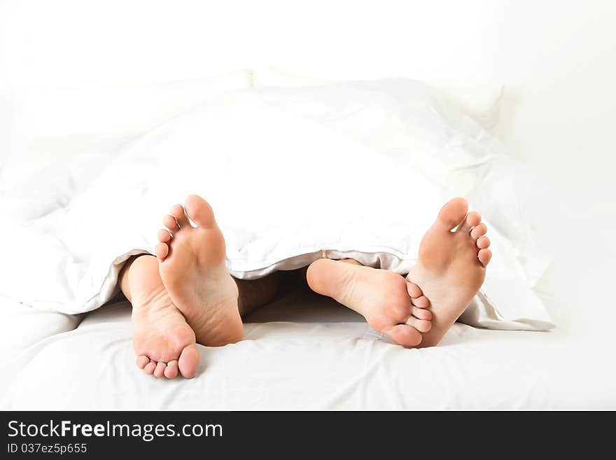 Foot of two people in the bedroom