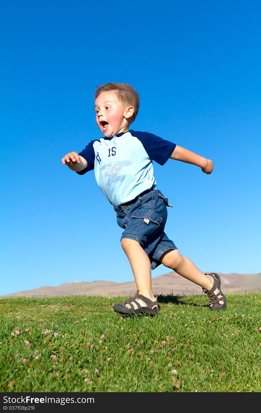 Little boy in fast move, park blue sky. Little boy in fast move, park blue sky