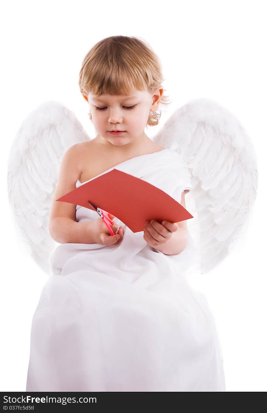 Boy angel with wings cut with scissors from red cardboard heart. Boy angel with wings cut with scissors from red cardboard heart