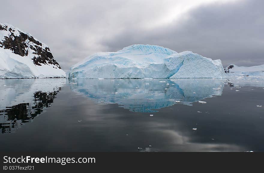 An iceberg scene is reflected in the Antarctic waters. An iceberg scene is reflected in the Antarctic waters