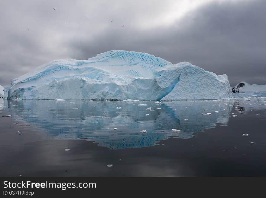 An iceberg scene is reflected in the Antarctic waters. An iceberg scene is reflected in the Antarctic waters