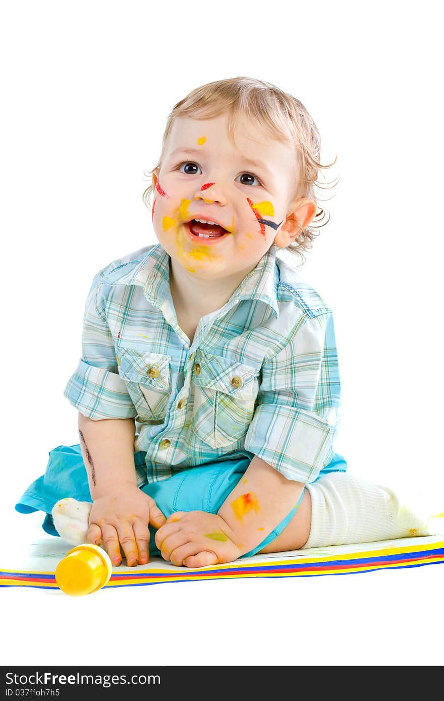 Beautiful baby covered in bright paint with paint brush.  Isolated.