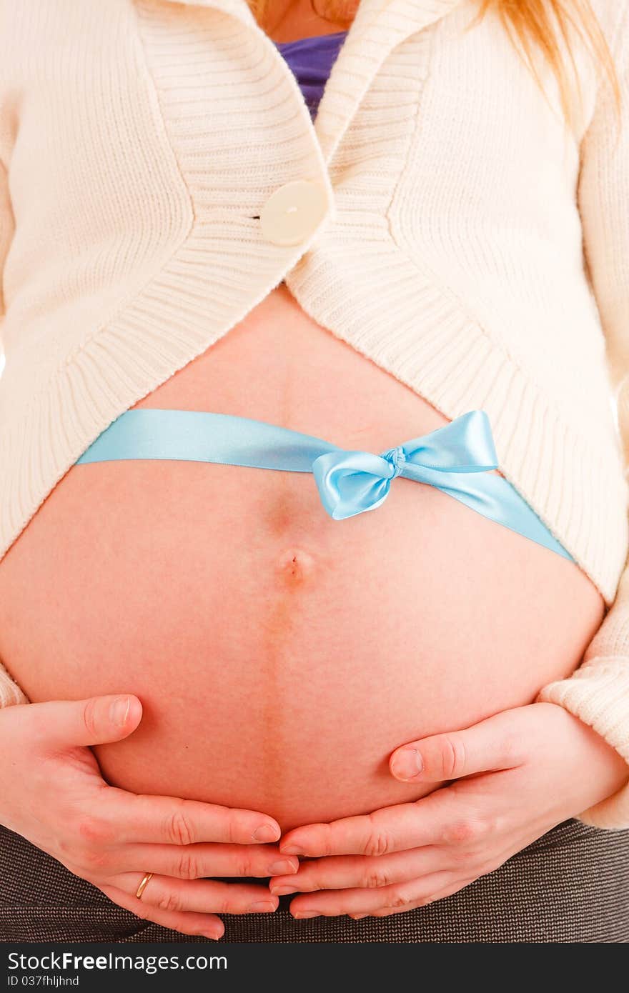 Close up of belly of pregnant woman with blue ribbon. Close up of belly of pregnant woman with blue ribbon