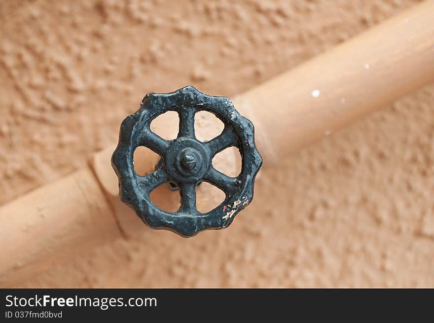 Value and pipe isolated against a light wall background. Value and pipe isolated against a light wall background