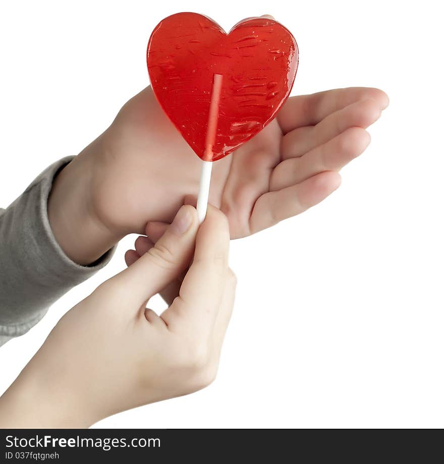 Candy red heart in the hands of a white background