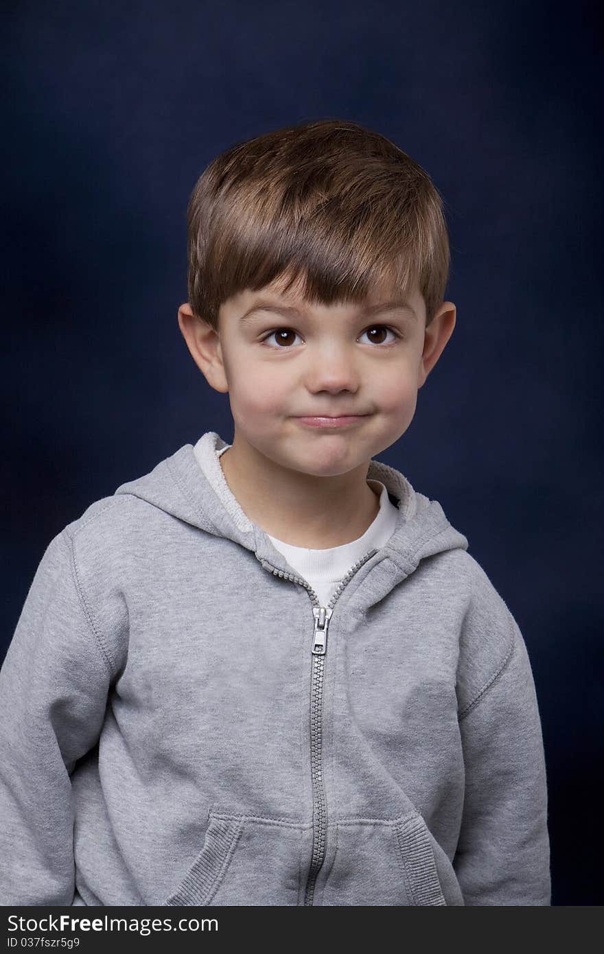 Toddler-aged boy with big brown eyes looking up with a sweet smile.