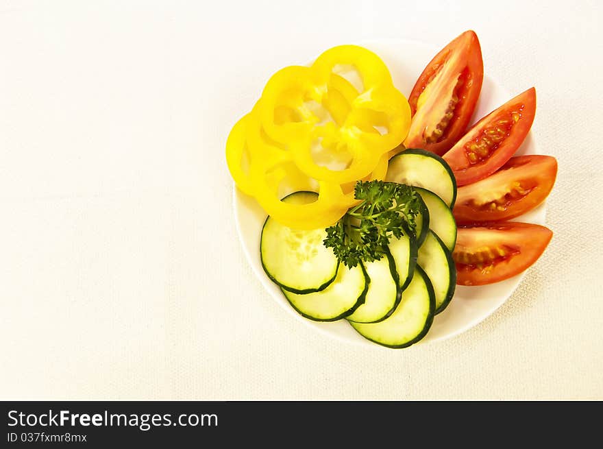 Colored raw vegetables for salad in plate on a table