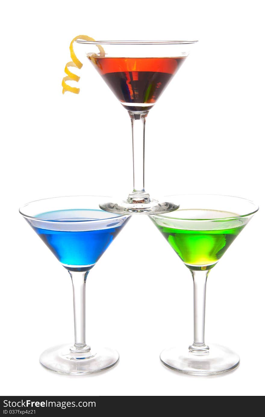 Colorful Martini Cocktails drink blue green and red on top composition with vodka, light rum, gin, tequila, blue curacao, lime juice in classic cocktail glasses isolated on a white background. Colorful Martini Cocktails drink blue green and red on top composition with vodka, light rum, gin, tequila, blue curacao, lime juice in classic cocktail glasses isolated on a white background