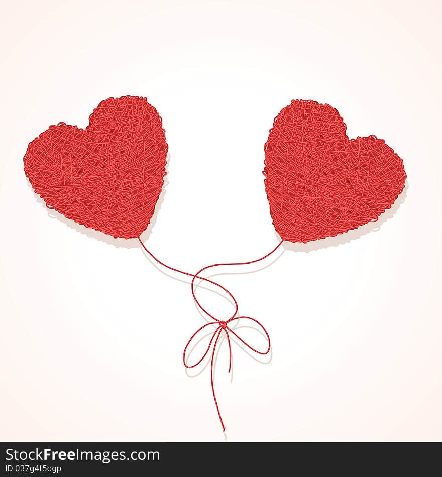 Two knotted balls of threads in form of heart on a white background