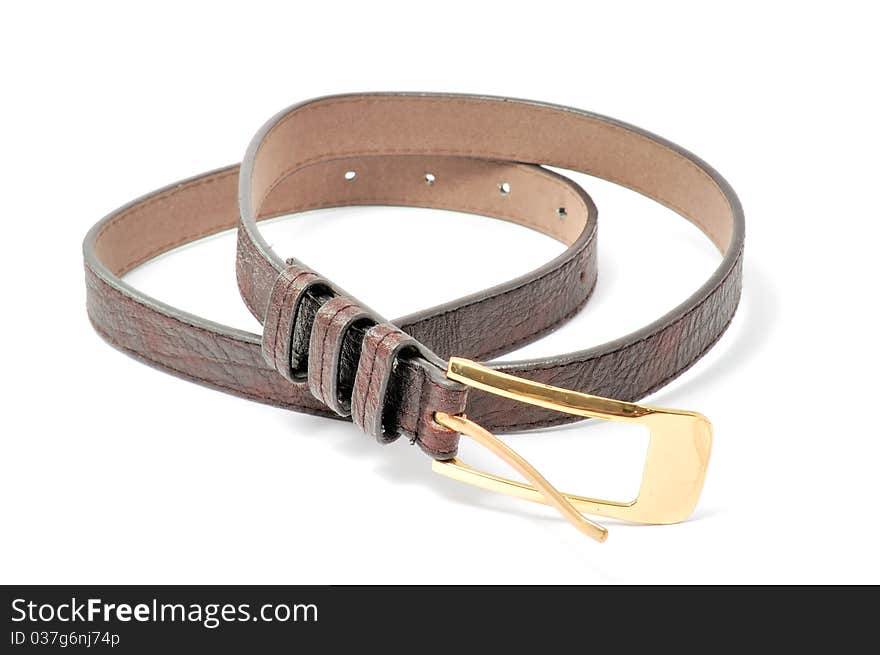 A brown leather belt with a golden buckle isolated on a white background. A brown leather belt with a golden buckle isolated on a white background