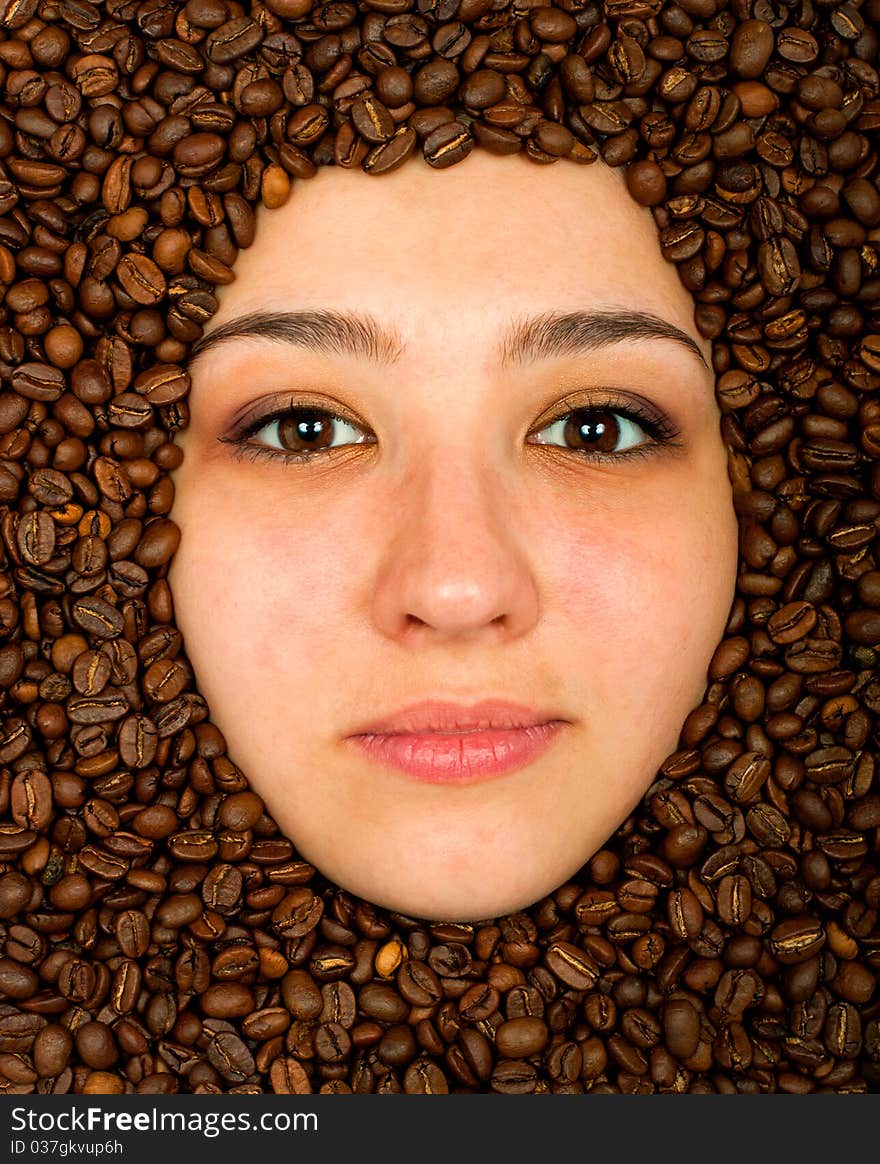 Coffee beans around of face beautiful young woman. Coffee beans around of face beautiful young woman