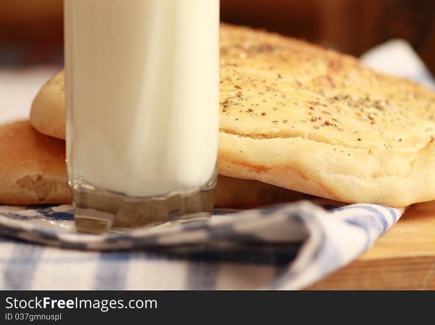 Homemade bread buns with sesame seeds and glass of milk