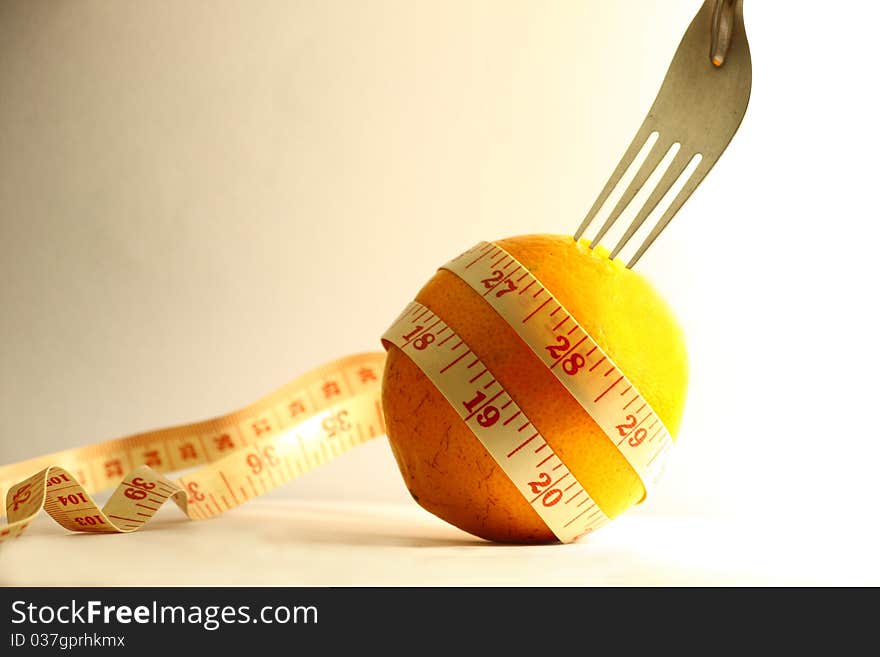 Orange with measurement tape and fork