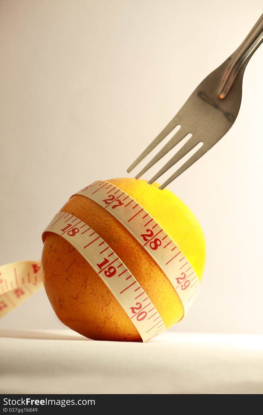 Orange with measurement tape and fork