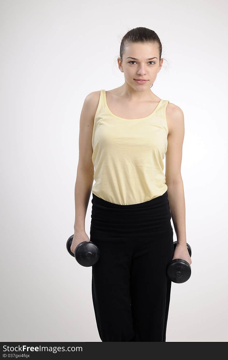 Young woman exercising with dumbbells. Young woman exercising with dumbbells