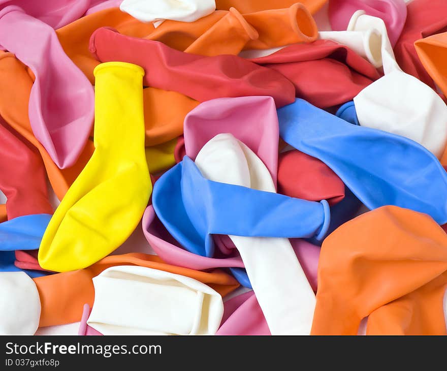 A lot of yellow, blue, red, orange, pink and white latex uninflating balloons