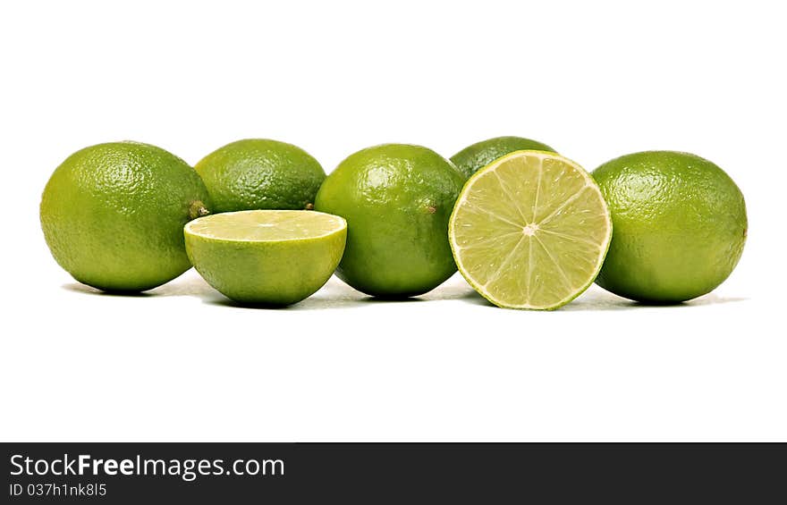 Whole and sliced limes, isolated on white