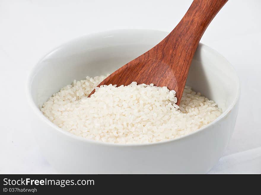 Rice with wood spoon in a bowl. Rice with wood spoon in a bowl