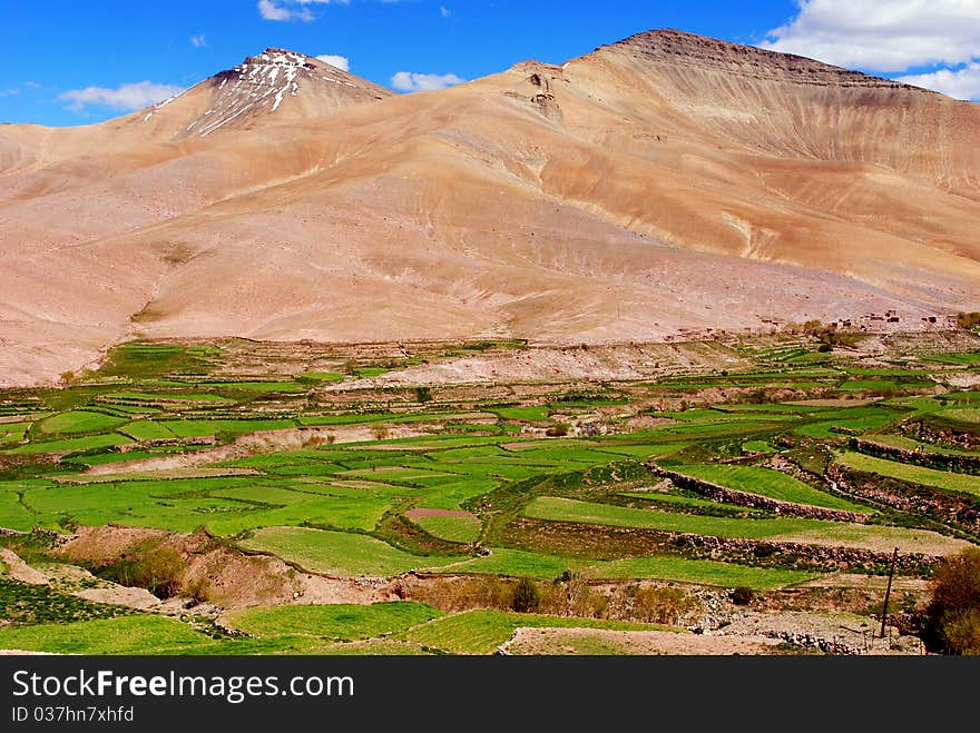 A beautiful scene with dark brown colored mountains and green rice paddy. A beautiful scene with dark brown colored mountains and green rice paddy.