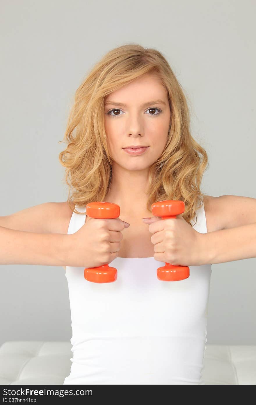 Young beautiful woman with dumbbells