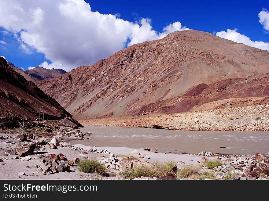 A beautiful mountain landscape scene with blue sky and white clouds. A beautiful mountain landscape scene with blue sky and white clouds.