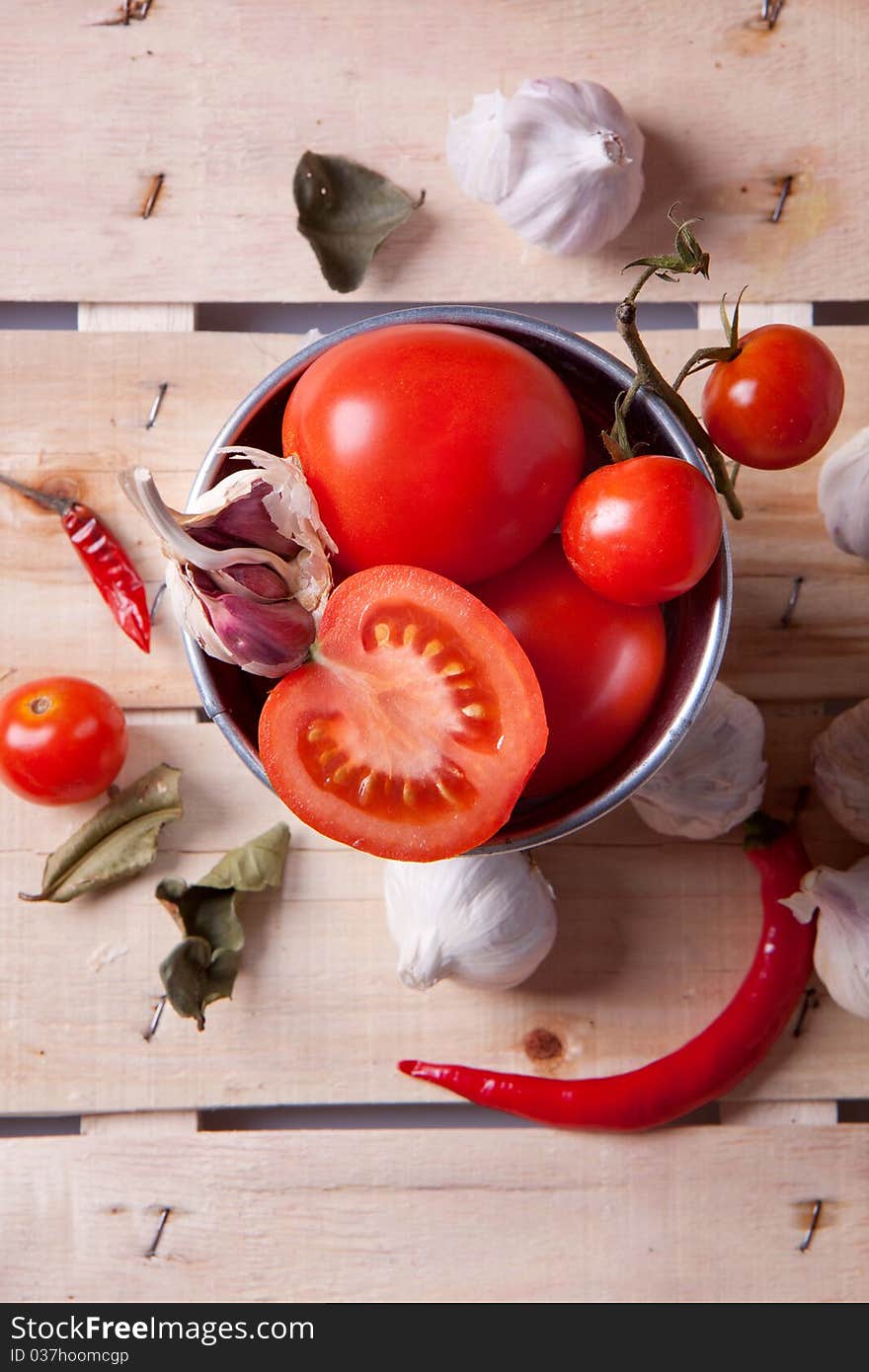 Tomato, garlic and pepper on a wooden desk